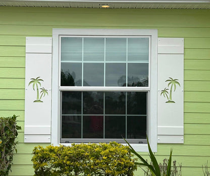Window with white shutters on a green house exterior
